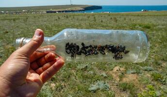A glass bottle thrown in nature - an insect killer, an ecological problem of garbage in nature, Crimea, Tarkhankut Atlesh photo