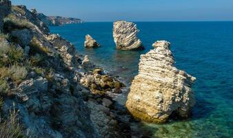 Rocks and islands in the water of the Black Sea near the landslide coast of Dzhangul in the western Crimea, Tarkhankut photo