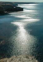 A path of sun glare on the water against the blue sky near the rocks on Tarkhankut, Atlesh photo