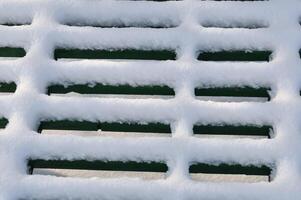Snow lies on the grate, beautiful design and play of light and shadow photo