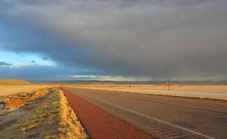 Roads during a red sunset and thunderclouds against the backdrop of the Guadalupe Mountains in New Mexico photo