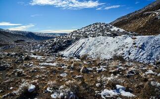 Snow in the mountains, Snow-covered mountain pass, desert plants under the snow in summer photo