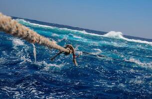Mooring with a thick rope to the Big Brother island of a diving yacht during a storm photo