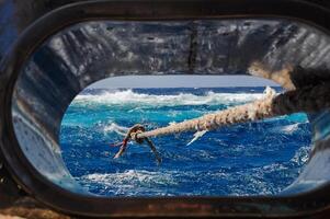 Mooring with a thick rope to the Big Brother island of a diving yacht during a storm photo