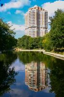 Reflection of a large house in the water of an artificial lake photo