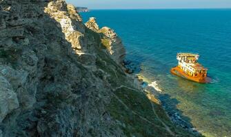 The remains of a sunken ship near the coastal cliffs in the tract Dzhangul, western Crimea photo