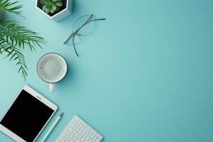 A serene workspace with greenery, tech, and a steaming mug on a turquoise desk during a quiet afternoon photo