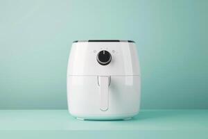 A sleek white air fryer resting on a mint green countertop in a modern kitchen setting photo