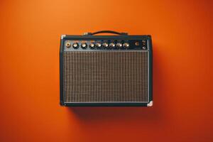 Vintage amplifier against a vibrant orange wall during a creative music session photo