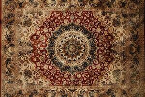 Intricate Persian carpet with floral motifs displayed on a wooden floor in warm lighting photo