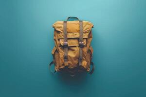 A rugged backpack resting on a vibrant blue surface, inviting adventure and exploration under soft, natural lighting photo