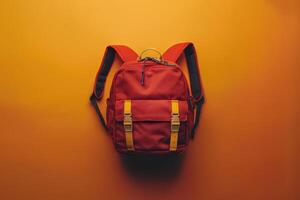 A vibrant red backpack stands out against a bright yellow background, showcasing its unique design and playful straps in a minimalist setup photo