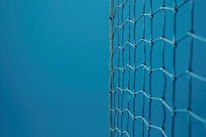 A close-up view of a delicate net against a serene blue background in a tranquil outdoor setting during midday photo