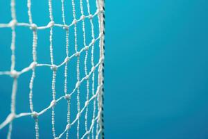 A close-up of a sports net against a vibrant blue background in a well-lit indoor arena photo