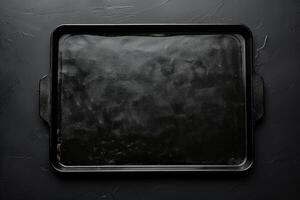 A polished baking tray resting on a textured dark surface, ready for culinary creations in a cozy kitchen environment photo