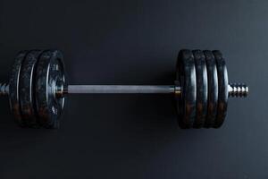 A powerful dumbbell rests on a dark surface, ready for a challenging workout session photo