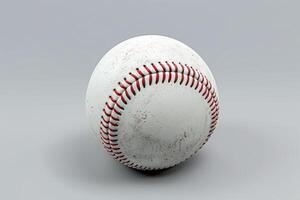 A well-worn baseball resting on a gray surface, capturing the essence of countless games played on sunny afternoons photo