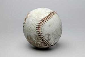 A worn baseball resting on a gray surface, showcasing signs of play and adventure, inviting nostalgia for the game photo