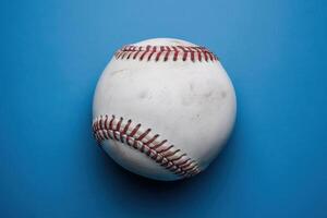 A well-worn baseball resting on a vibrant blue background under soft lighting, inviting nostalgic memories of summer games and friendly competitions photo