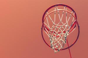 A vibrant basketball hoop against a warm sunset sky inviting play and passion in the heart of the city photo