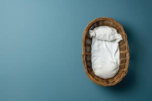 A serene newborn resting peacefully in a cozy wicker basket against a calming blue backdrop photo