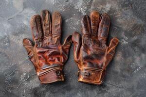 Stylish vintage leather gloves resting on a textured surface, showcasing craftsmanship and wear from a rich history photo