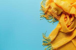 Bright yellow scarf elegantly draped on a vibrant blue surface, capturing the essence of warmth and style photo