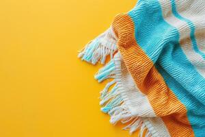 Cozy striped blanket draped elegantly over a vibrant yellow surface in a warm, inviting setting photo