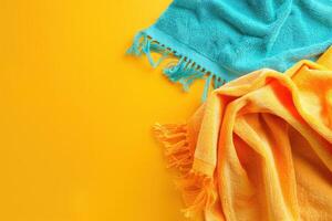 Two vibrant beach towels sprawled across a sunny yellow background, inviting relaxation and summer fun photo