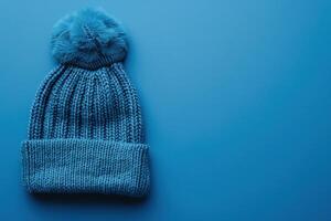 Cozy blue knitted beanie resting on a vibrant blue background photo