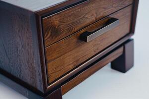 Elegant wooden nightstand with a sleek drawer and modern design in a bright indoor setting photo