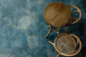 Cozy cafe corner in the afternoon with a rattan table and chair on a textured blue floor photo