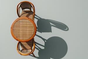 A rustic wooden table with woven chairs casting gentle shadows in warm afternoon light photo