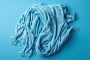 Soft, cozy blue blanket draped elegantly on a vibrant turquoise background photo