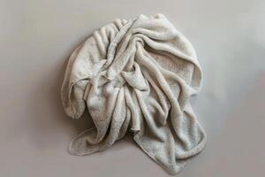 Soft beige blanket softly draped on a minimalist surface in a cozy indoor setting photo