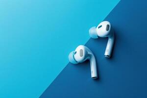 Stylish wireless earbuds resting on a vibrant two-tone surface, capturing modern technology in an artistic display photo