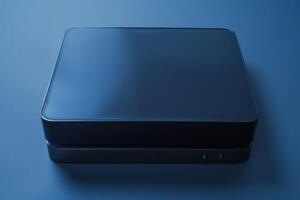 A sleek black device resting on a smooth blue surface in soft ambient light photo