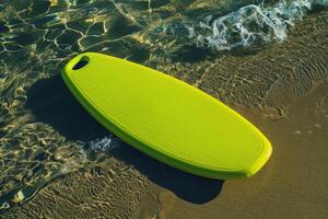 A vibrant green boogie board resting on sun-kissed sand beside gentle ocean waves during a bright summer day photo