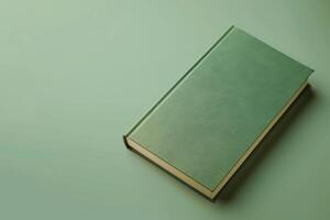 A solitary green book rests on a soft pastel surface, inviting curiosity and exploration in a serene moment of contemplation photo
