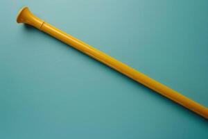 A vibrant yellow trumpet-shaped tool rests on a teal background, showcasing a playful contrast and simple elegance in design photo