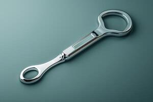 Sleek stainless steel hand tool resting on a smooth surface in soft, diffused light photo