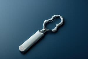 Sleek stainless steel bottle opener resting on a dark surface, showcasing its modern design and functionality photo
