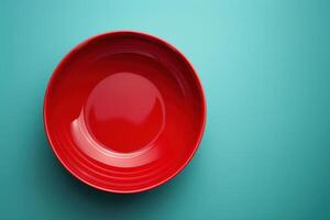 A vibrant red plate resting on a soothing turquoise surface, capturing the simplicity of modern home decor photo