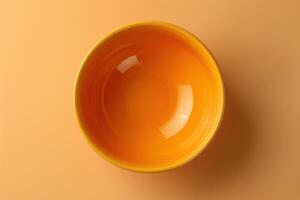 A vibrant yellow bowl resting on a warm orange backdrop, capturing the essence of simplicity and color harmony photo