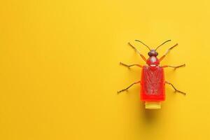 A vibrant red insect perched on a bright yellow surface during a playful art installation photo