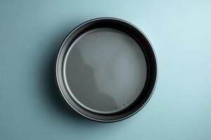 A sleek black plate resting on a calm blue surface, ready for a culinary masterpiece, captured in soft lighting photo