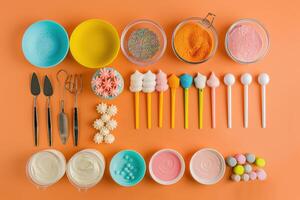 Colorful sprinkles and frosting decorations laid out on a vibrant orange surface for a festive baking project photo