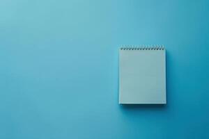 A blank notepad resting on a calming blue background, inviting creativity and ideas to flow freely photo
