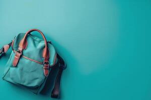 A stylish backpack rests on a vibrant turquoise surface, inviting exploration and adventure in a modern urban setting photo