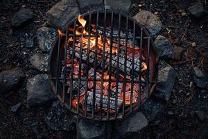 Evening warmth from glowing embers in a rustic campfire pit surrounded by stones photo